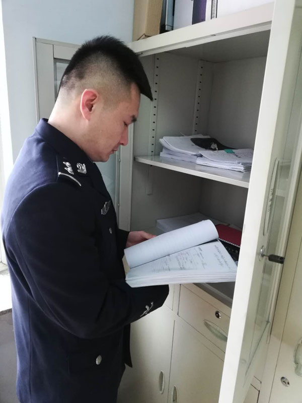 圖二，辛楊查閱卷宗，在一摞摞卷宗材料中尋找線索