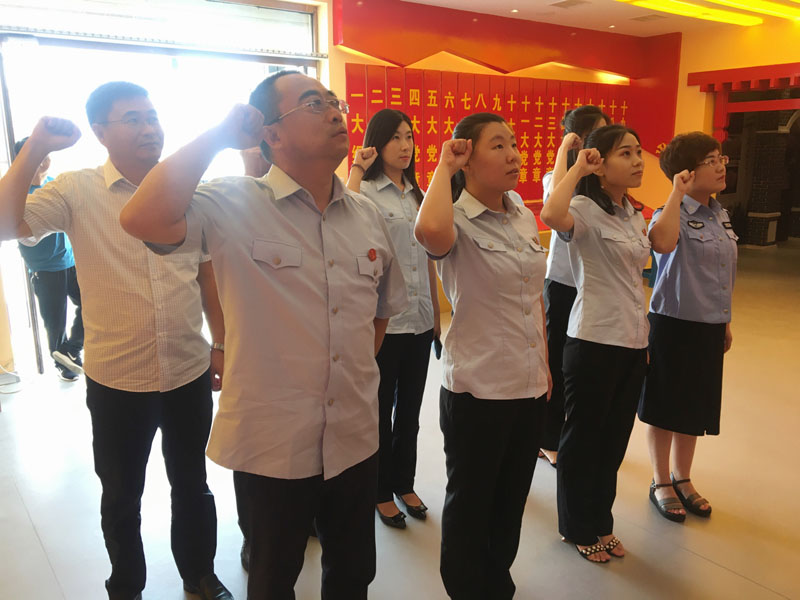 大洼法院干警面對(duì)黨旗進(jìn)行重溫入黨誓詞活動(dòng)。
