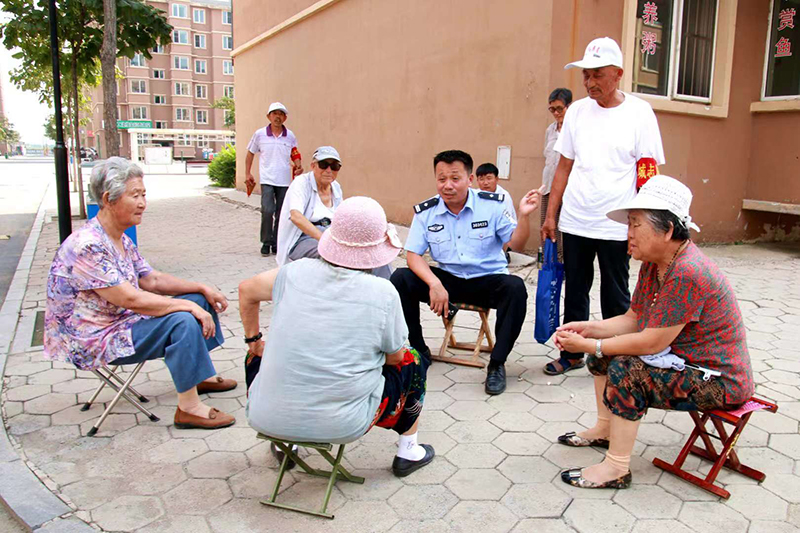 李化瑞和轄區(qū)群眾聊家常，聽取他們對小區(qū)平安建設的意見和建議。