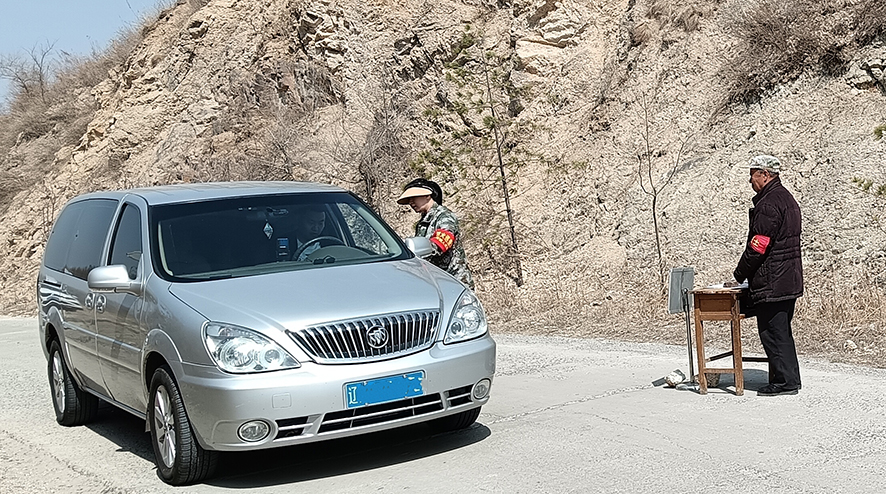 佟玲（右二）在對(duì)過往車輛檢查登記