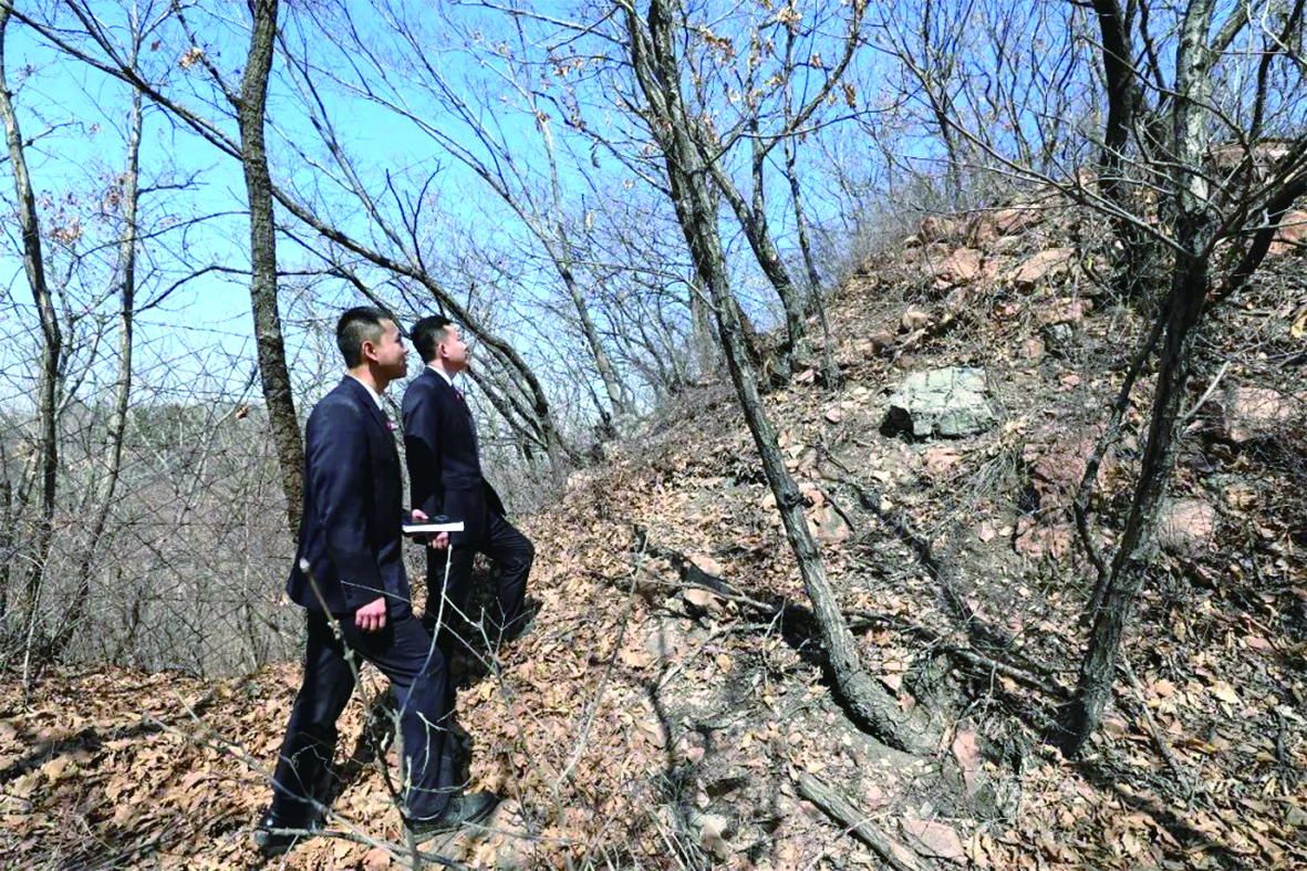 檢察官在長(zhǎng)城烽火臺(tái)遺址附近勘察取證。李奇峰 攝