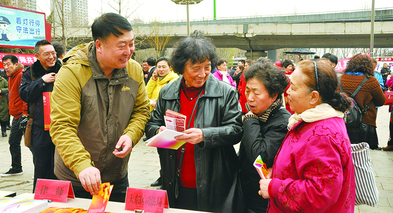 張京濤（左）到街頭開展普法宣傳活動(dòng)