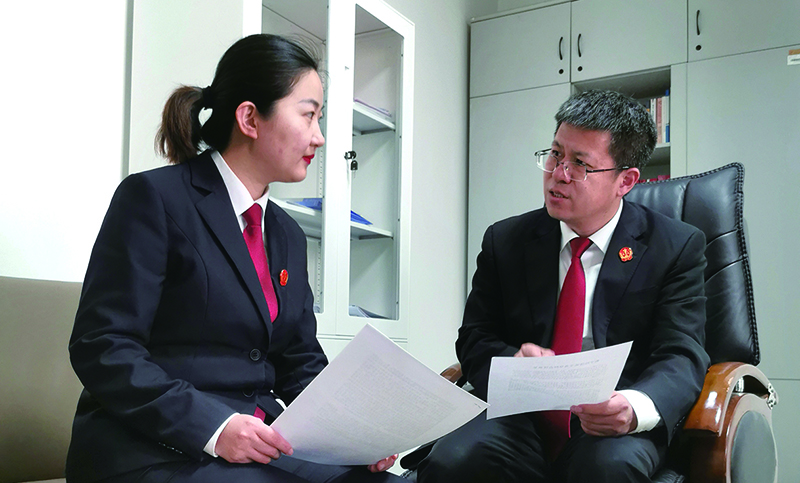 省法院民事審判第三庭庭長董凱（右）就結(jié)項論文內(nèi)容對楊蒙進行指導(dǎo)