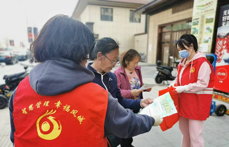 丹東圖，志愿者向居民發(fā)放建設(shè)文明小區(qū)傳單